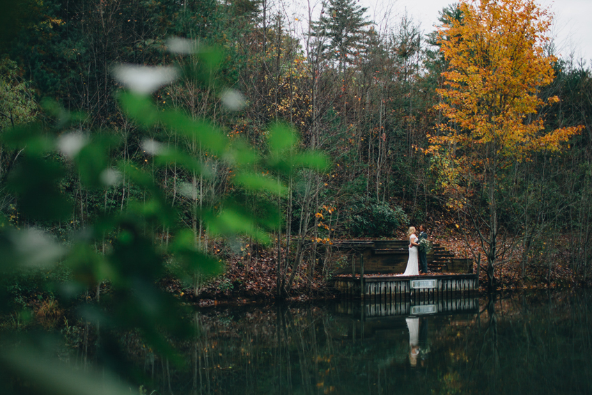 Bride & groom on a dock by the lake for a rustic, fall wedding in the Georgia mountains