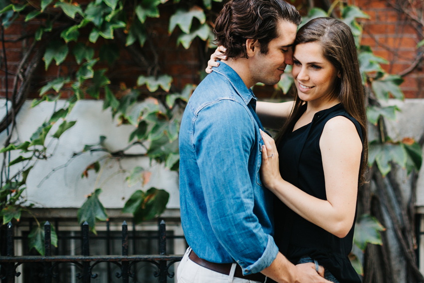 Candid engagement photos in front of an ivy covered brownstone in the West Village of NYC