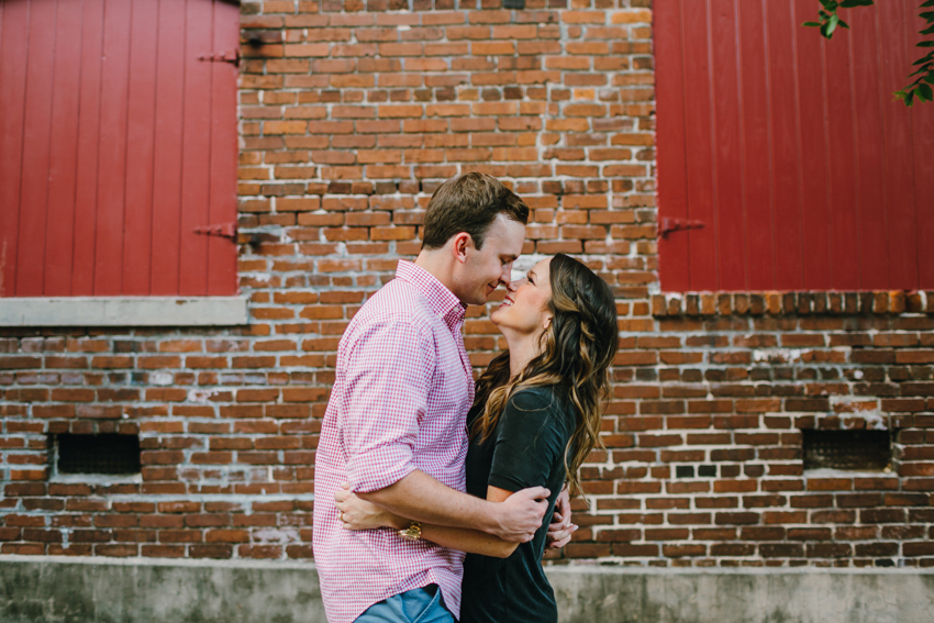 Romantic engagement photos at sunset in front of a brick wall in historic Ybor City Tampa