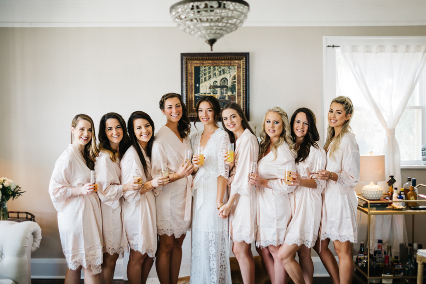 bridesmaids wearing blush colored robes with lace detailing