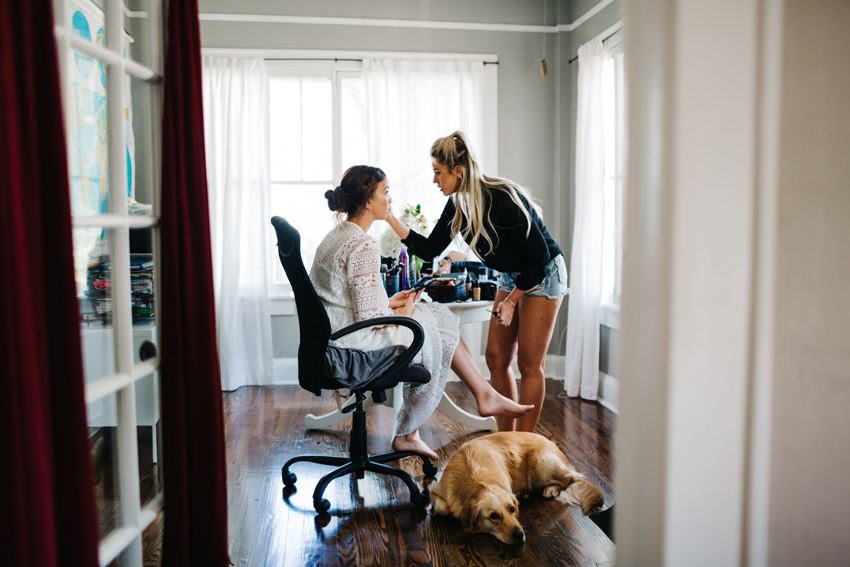 bride getting her makeup done with her golden retirever puppy