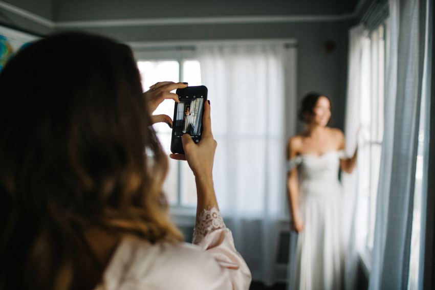 bridesmaid taking a photo of the bride