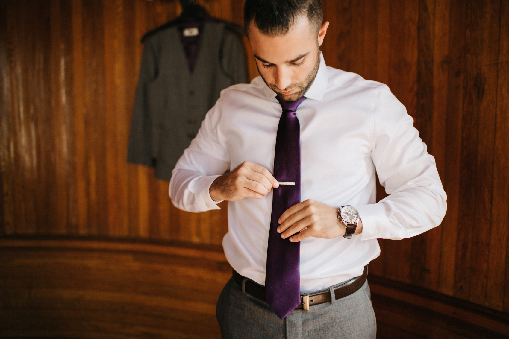 Groom wearing a purple tie and custom grey suit from Men's Warehouse