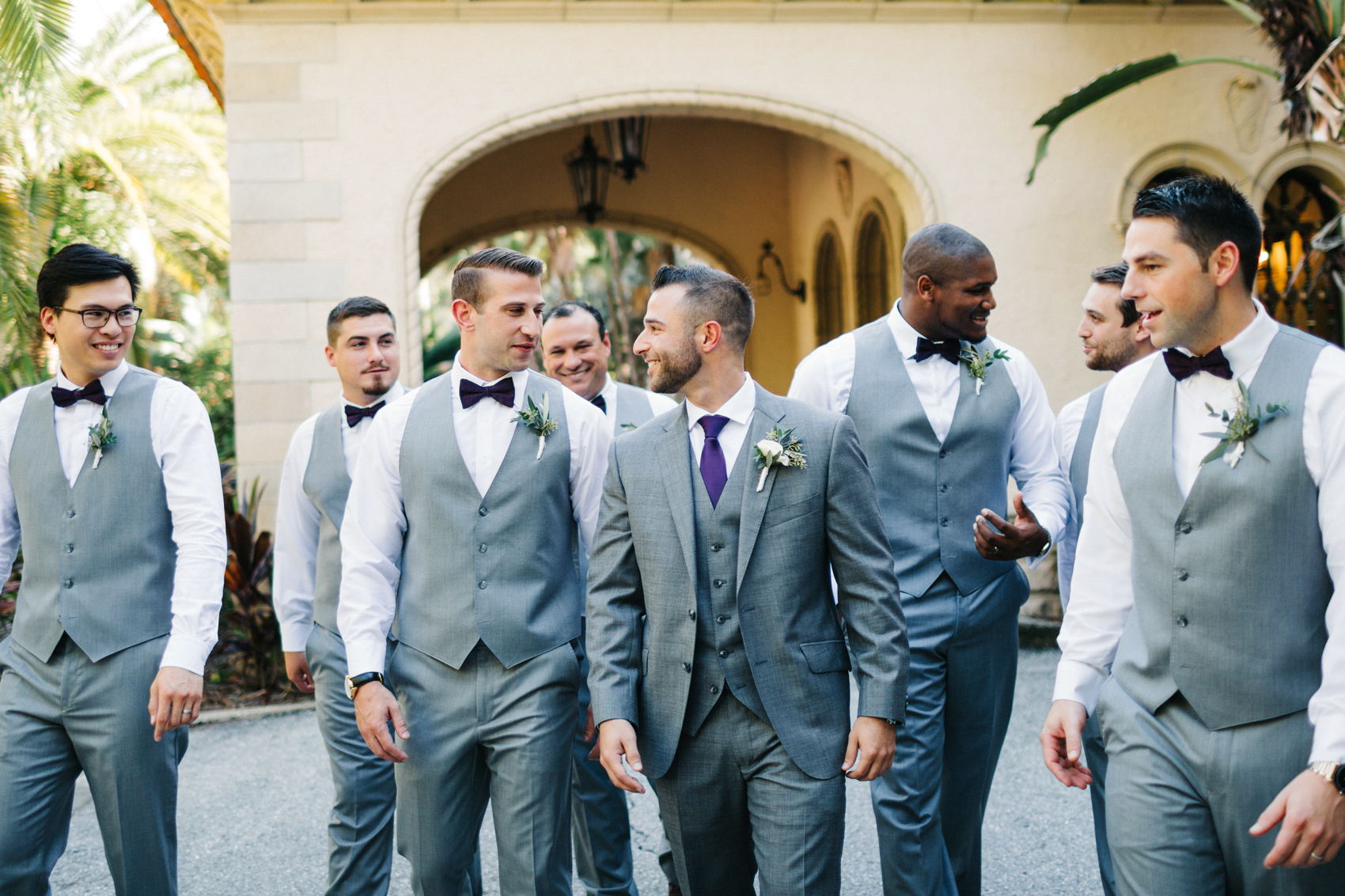 Candid photo of the groom hanging out with his groomsmen before the wedding ceremony