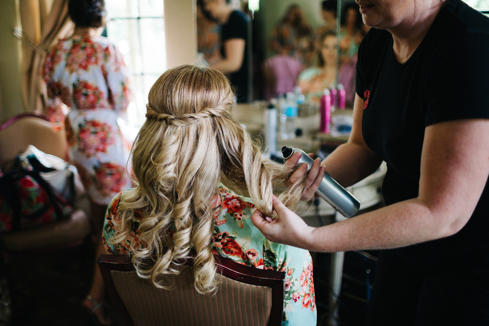 Bridesmaid getting her hair done with a half updo french braid