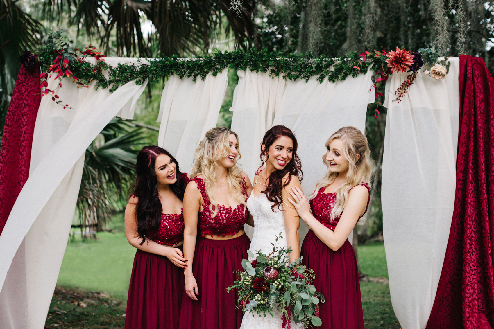 Bridesmaids wearing crop top maroon burgundy dresses