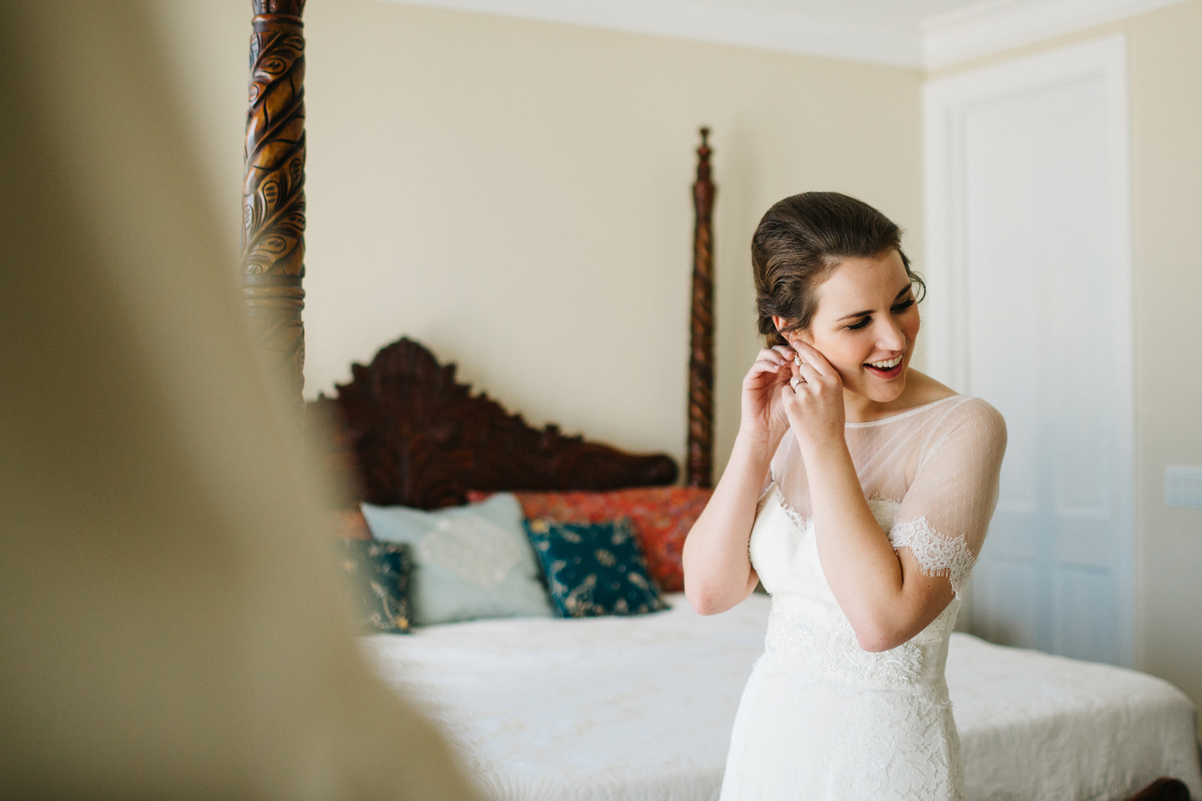 bride putting her earring on in the bridal suite