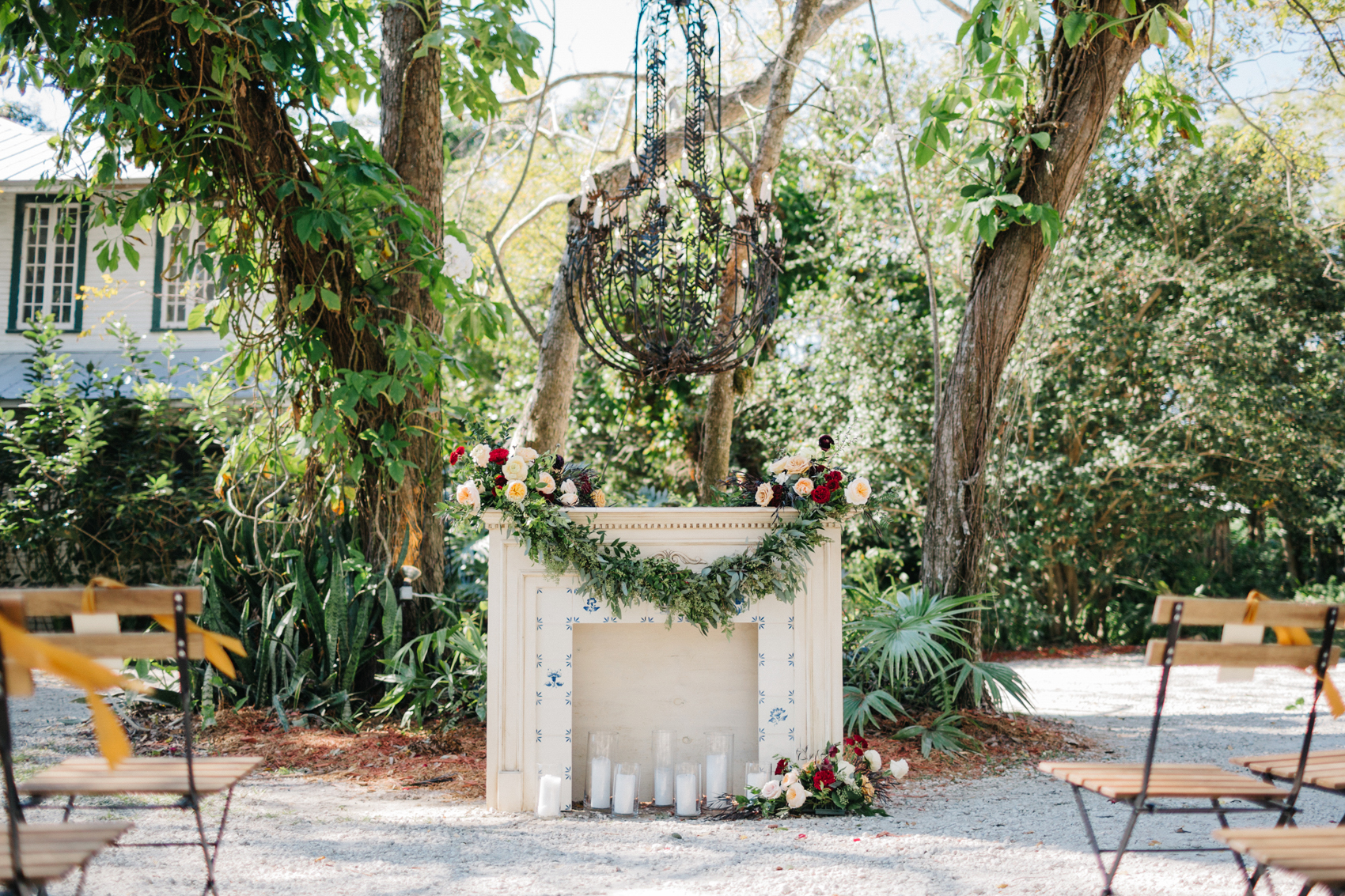 vintage mantle at the garden ceremony with romantic candles and a garland of greenery and flowers