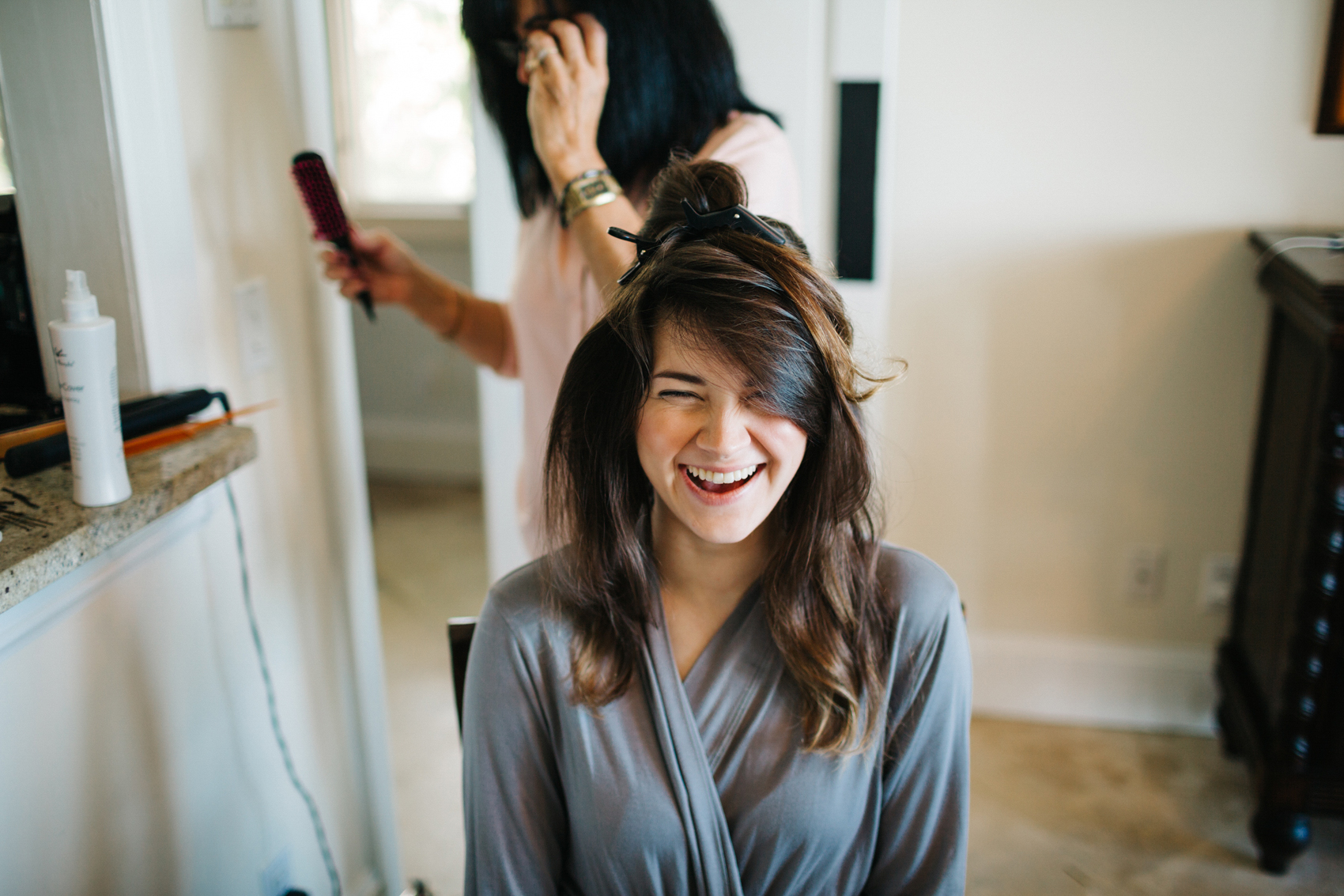 bridesmaid wearing a light grey robe while getting ready before the wedding