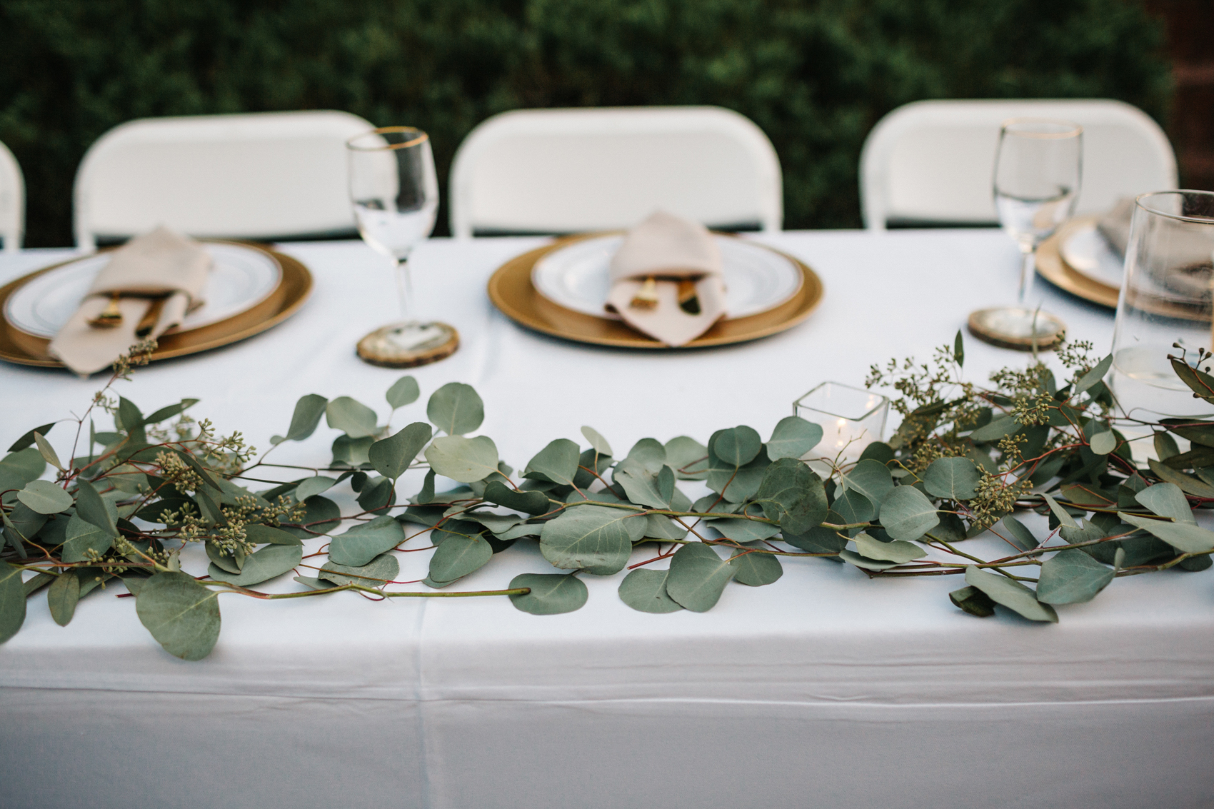 greenery table runners for rustic barn wedding with gold chargers and tree slice coasters