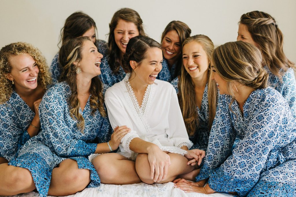bridesmaids laughing and wearign matching robes