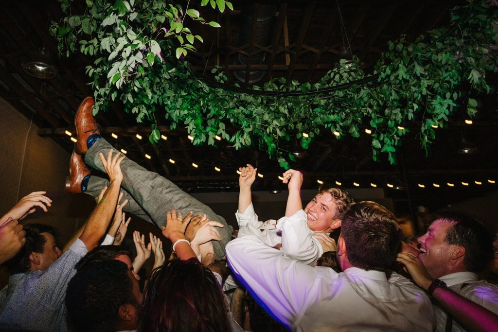 groom crowd surfing at fun wedding party with dj cory barron