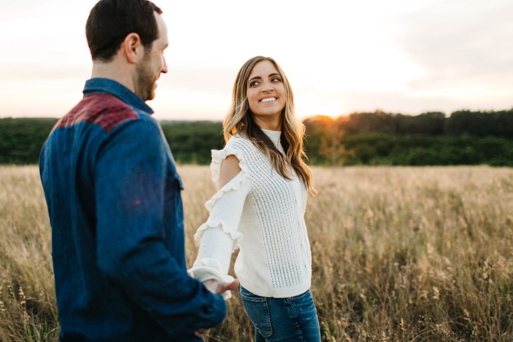 golden sunset engagement photos in a field by orlando wedding photographer