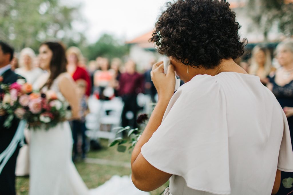 sweet maid of honor wiping away tears during the ceremony