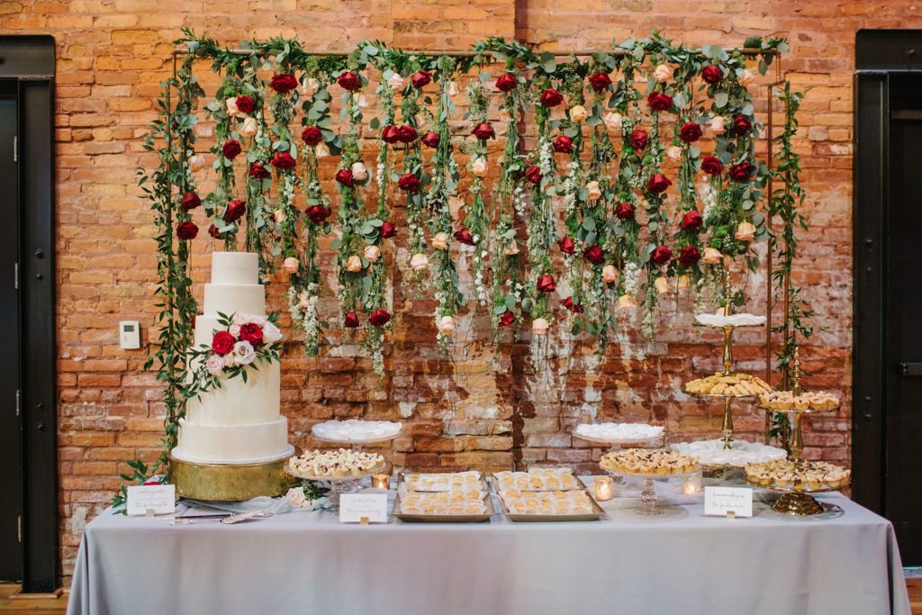 Stunning dessert table with floral backdrop and mini desserts
