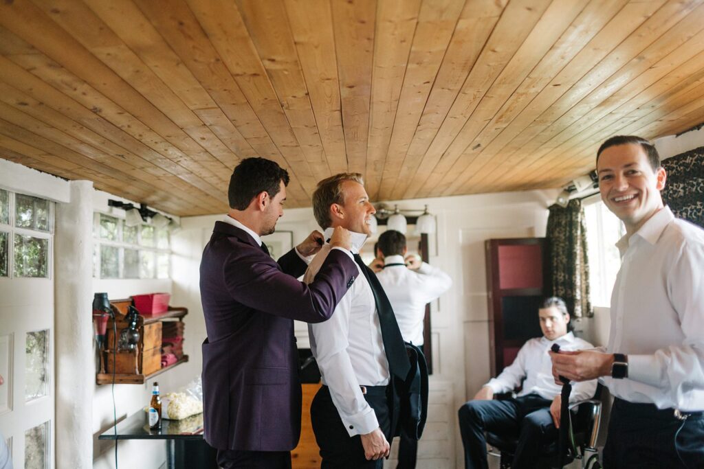groom helping his groomsmen get ready