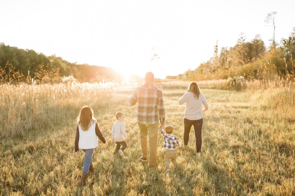 Family walking towards the sunset in a field