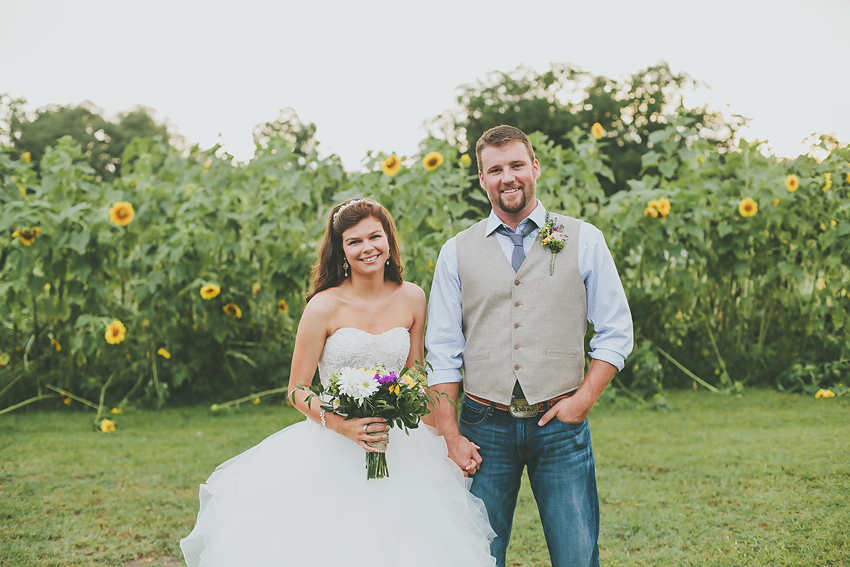 Bride and groom at rustic barn wedding in the Sweetfields Farm sunflower field