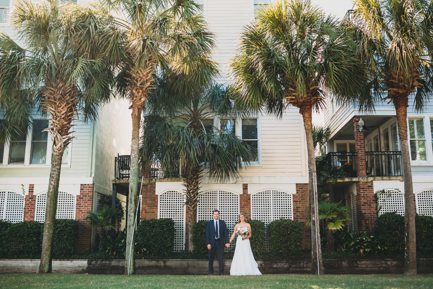 Bride and groom standing between Palm Trees in Charleston