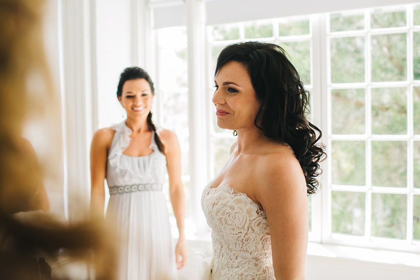 Bride putting on beautiful lace Anne Barge wedding gown in Sarasota