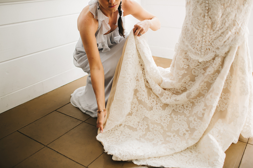 Bride putting on beautiful lace Anne Barge wedding gown in Sarasota