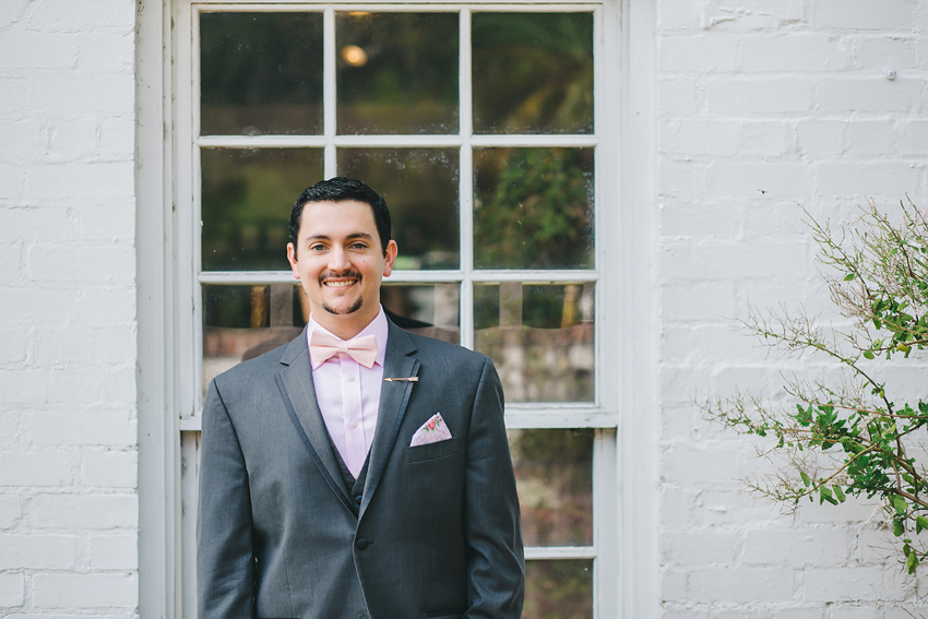 Groom in grey tux and pink bow tie