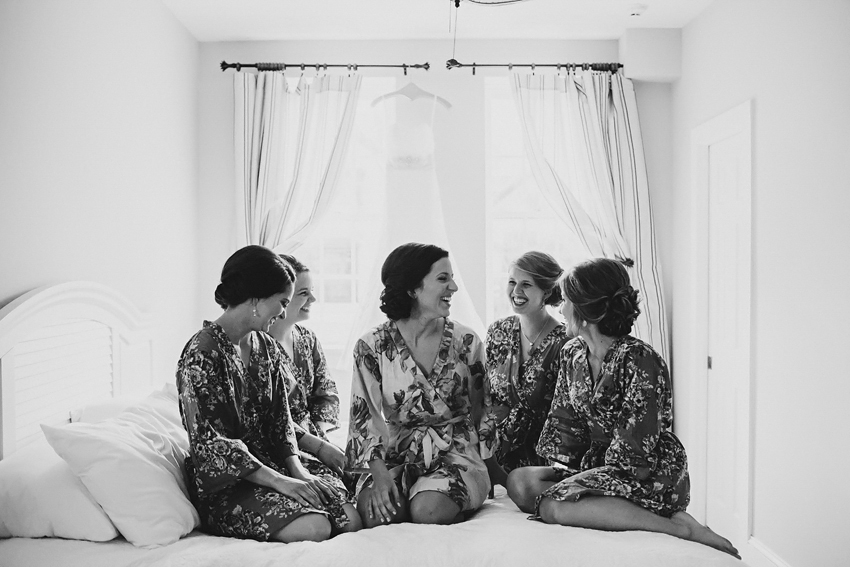 bride and bridesmaids laughing before the ceremony wearing cute floral robes