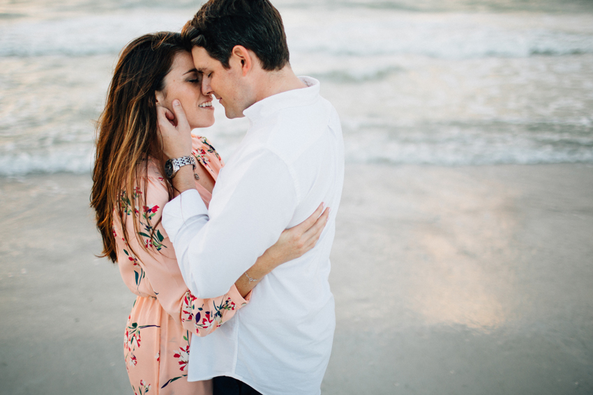 Beach engagement session photos at sunset in front of the water