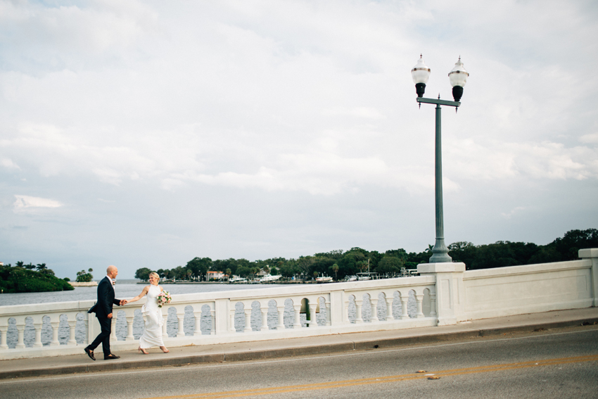 Bride and groom walking along the waterfront bridge in St. Pete Florida wedding photos