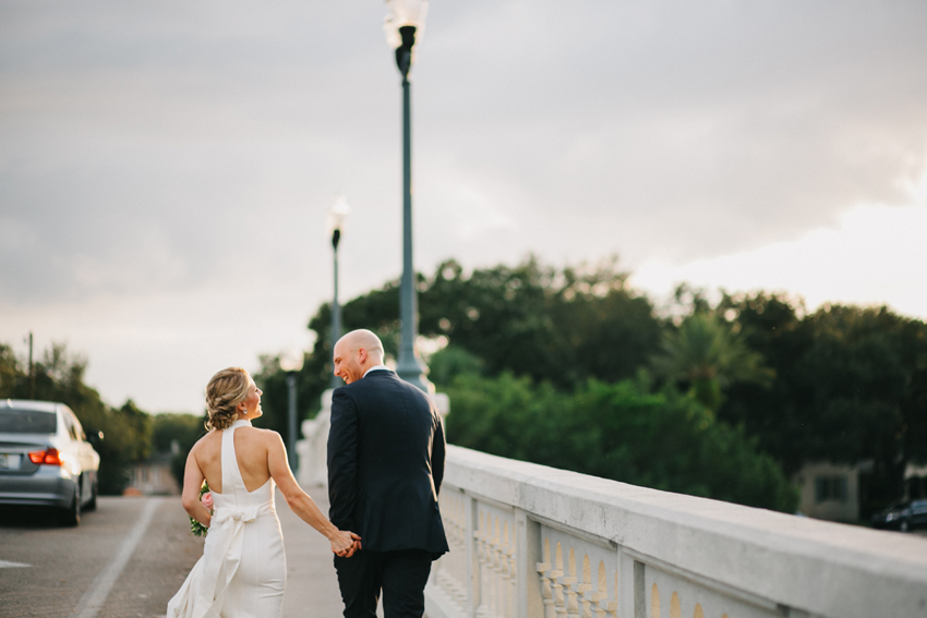 Bride and groom walking along the St. Pete bridge