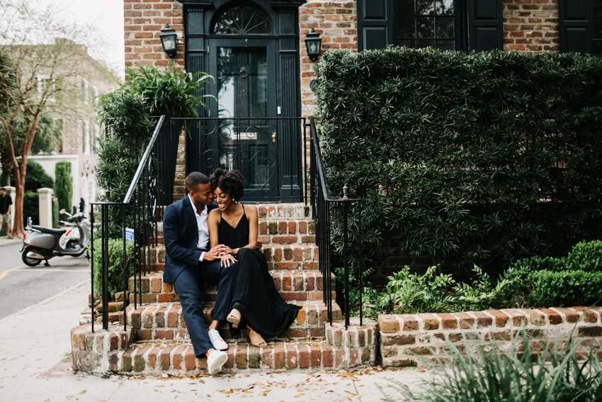 couple sitting on the brick staircase in historic downtown charleston