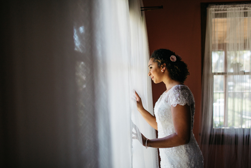 Bride looking out of the window of her bridal suite in the Acre Orlando