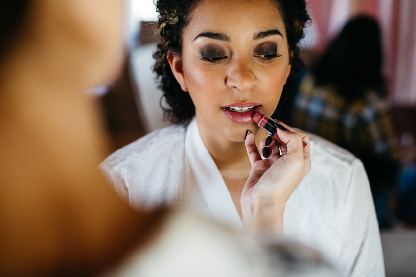 bride getting her makeup done before her outdoor wedding at the acre in orlando florida