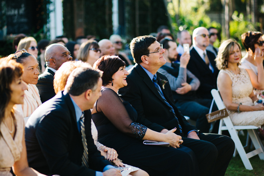 candid photography of parents watching the outdoor backyard ceremony