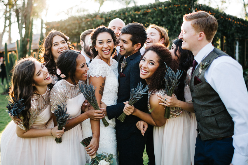 Stylish bridal party laughing and cheering before the outdoor reception on the lawn at The Acre in Orlando Florida