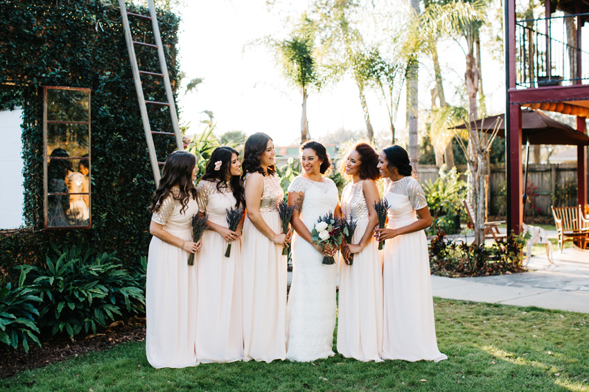 Bridesmaids laughing at sunset before the outdoor reception on the lawn at The Acre in Orlando Florida
