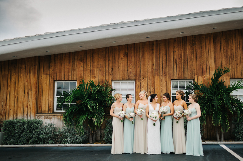 Bridesmaids laughing in their pastel floor-length gowns