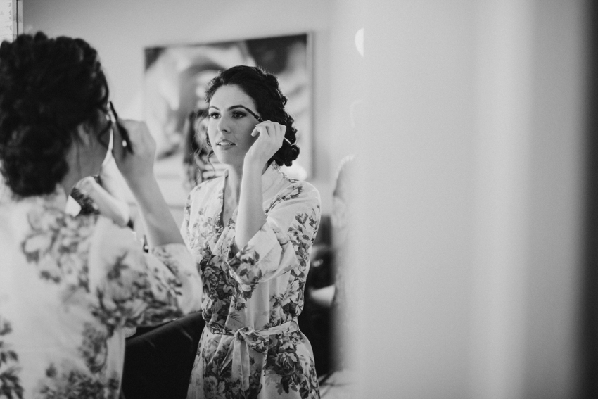 Bride touching up her makeup in the mirror before the ceremony in St. pete