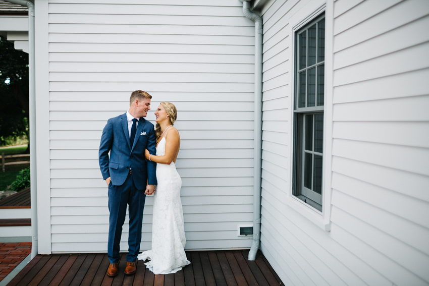 Stylish bride and groom laughing during their first look in Newport, Rhode Island by Renee Nicole Photography