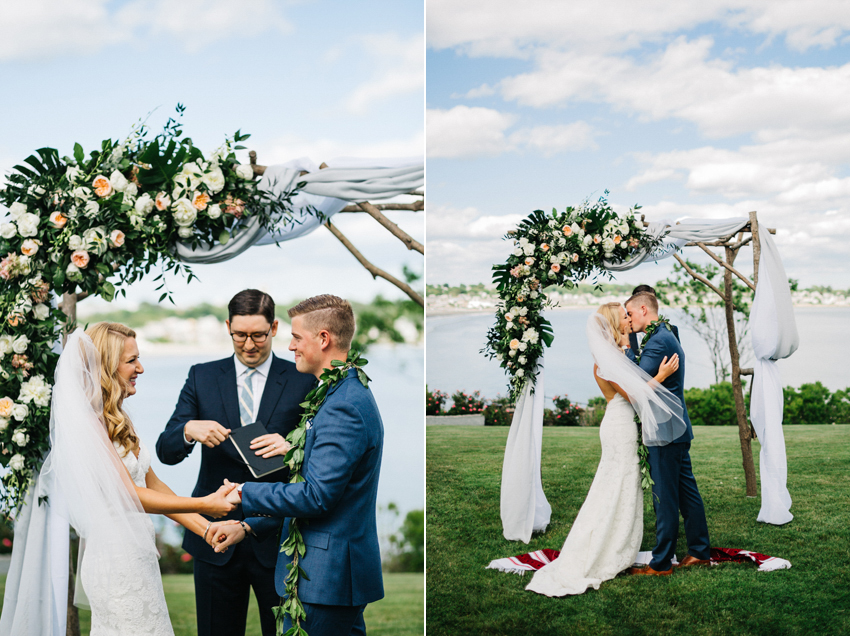 Natural light romantic wedding photo of the first kiss after their outdoor waterfront ceremony in Newport by destination wedding photographer Renee Nicole Photography