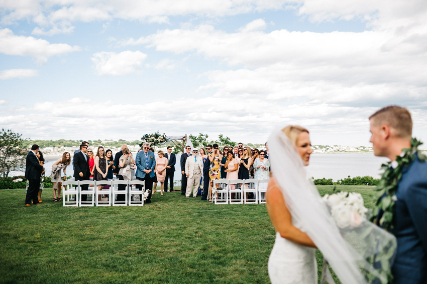 Guests cheering for the newlyweds after the outdoor wedding ceremony at The Chanler in Newport, Rhode Island
