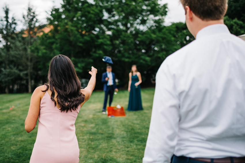 Cocktail hour cornhole games on the lawn during a coastal New England wedding in Newport