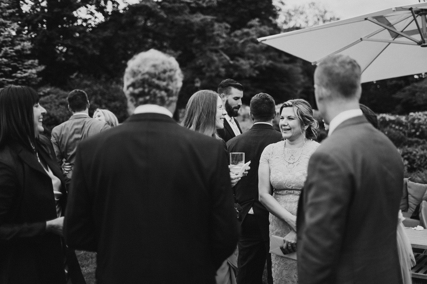 Candid wedding photography of guests laughing and mingling during cocktail hour