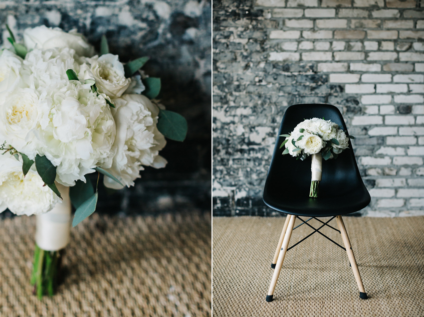 Lush white peony bouquet sitting in a mid century modern chair with exposed brick walls at the Oxford Exchange