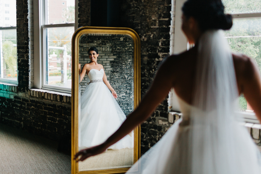 Natural light wedding photo of the bride getting ready in a gold mirror at The Oxford Exchange