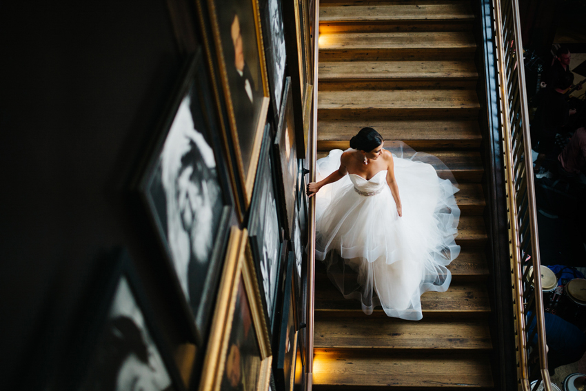 modern and creative wedding photography of bride walking down the stairs to the first look at the Oxford Exchange