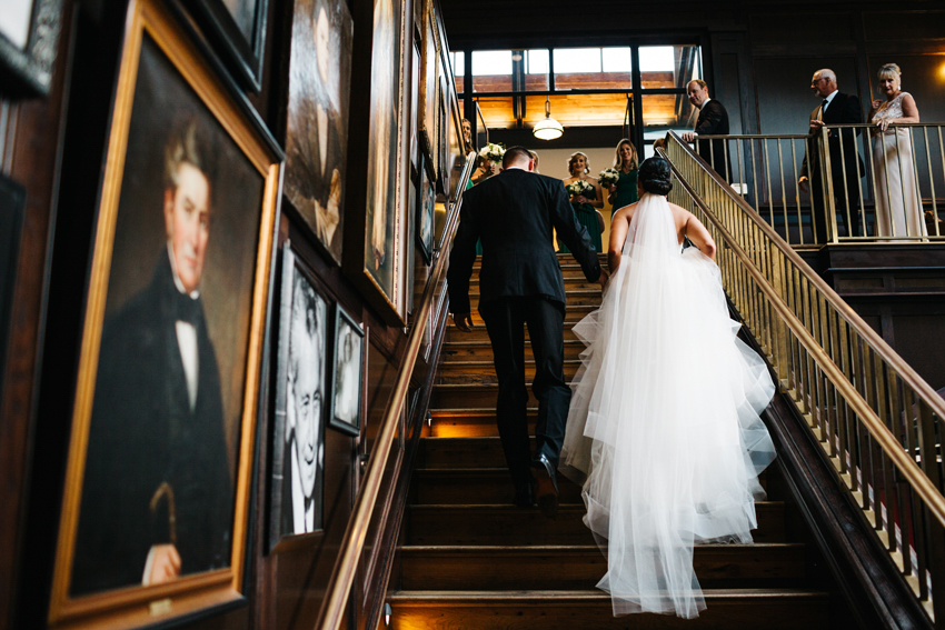 Bride and groom walking up the grand staircase at The Oxford Exchange in downtown