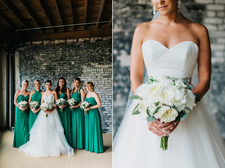 Emerald green bridesmaid dressed with white peony bouquets in a Tampa venue with exposed brick walls
