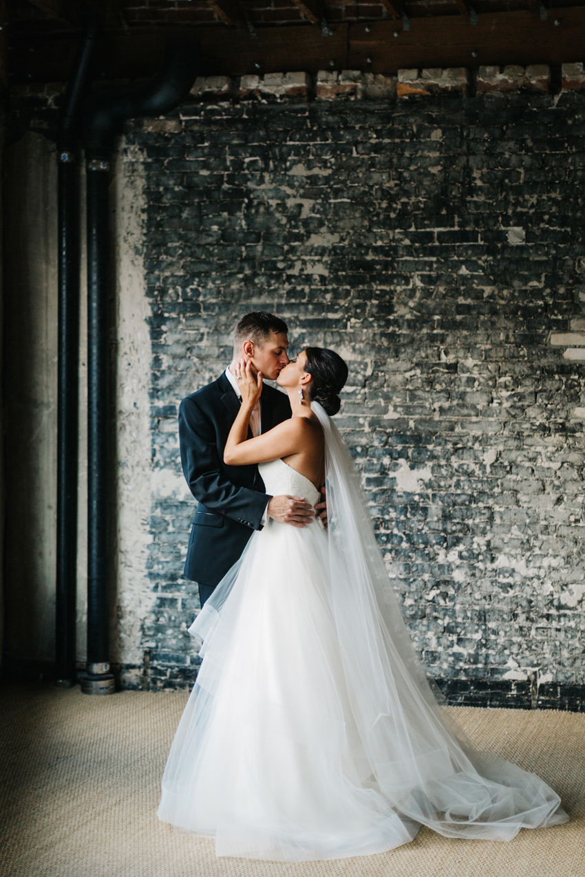 Romantic wedding photography with an industrial loft brick wall and natural window light in Tampa, FLorida at the Oxford Exchange