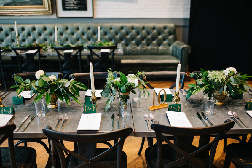 Industrial classic wedding details with gold metal accents and lush greenery centerpieces